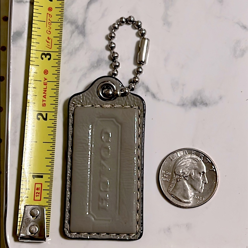 Coach crinkle Patent leather hang tag with silver tone chain and hardware.
